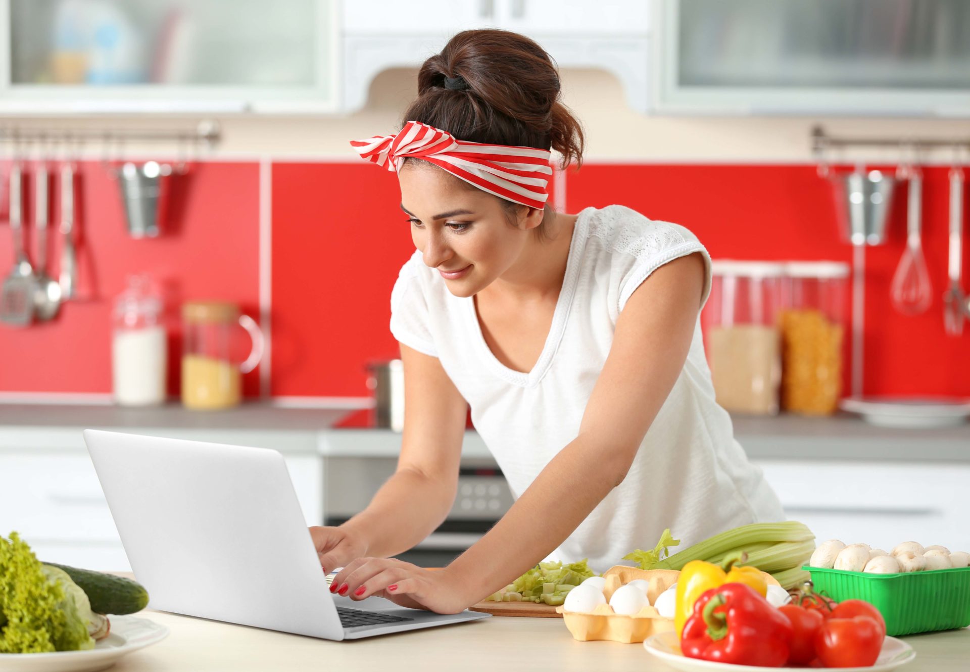 Woman in kitchen looking at computer